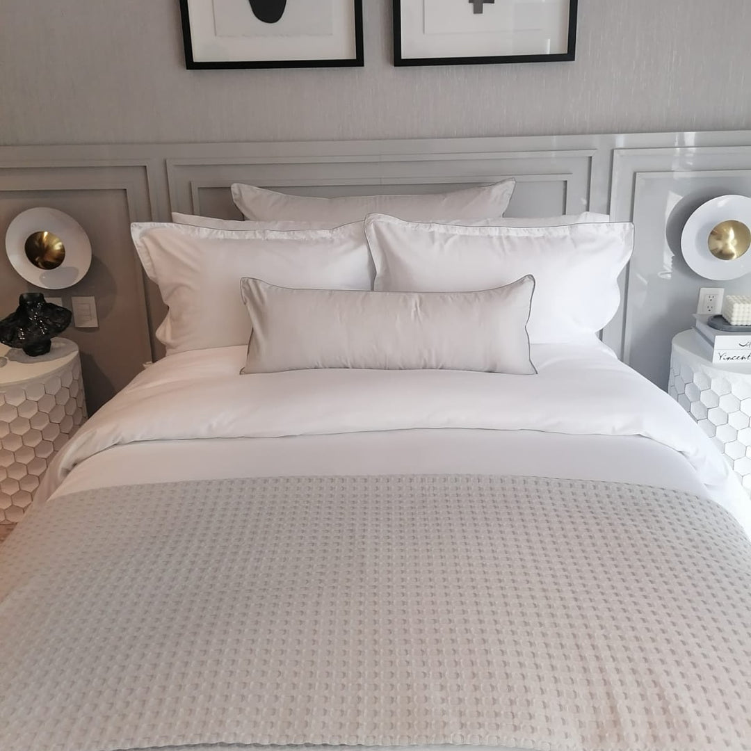 Sobrecama ligero del algodón sobre una cama en un ambiente minimalista y estético