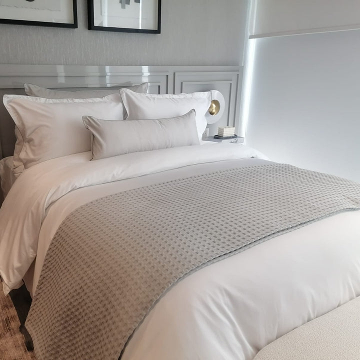 Sobrecama ligero del algodon sobre una cama en un ambiente minimalista y estético