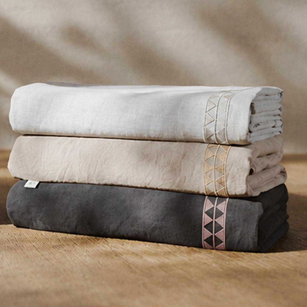 Fundas duvet Alba dobladas en tres tonos, con detalle de bordado geométrico.