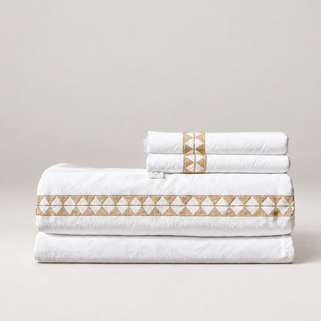 Juego de Sábanas Alba blanco con bordado khaki y fundas de almohada, presentado doblado.