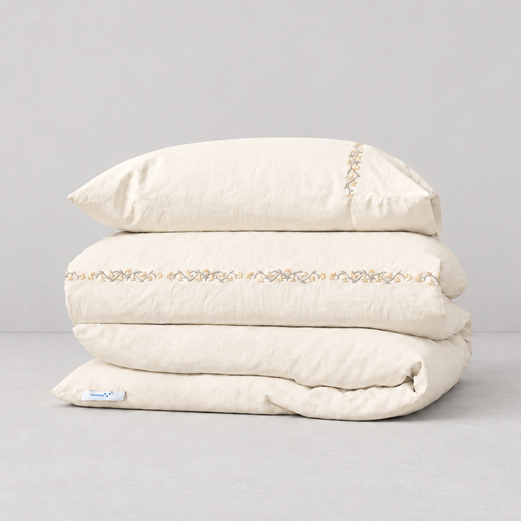 Funda Duvet Chicori de algodón percal crudo con bordado floral Crudo+Bruma y fundas de almohada, presentada doblada.