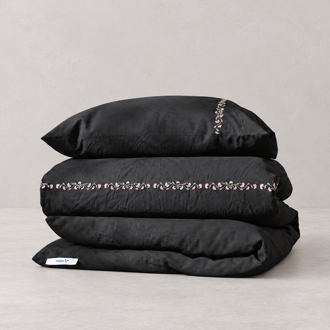 Funda Duvet Chicori de algodón percal noche con bordado floral Rosa+Laurel y fundas de almohada, presentada doblada.