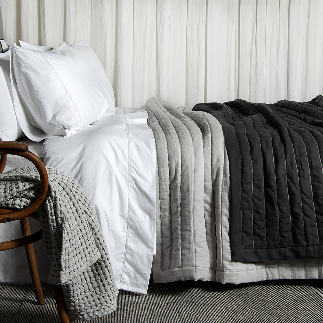 Coverlet Monte Noche sobre cama blanca.