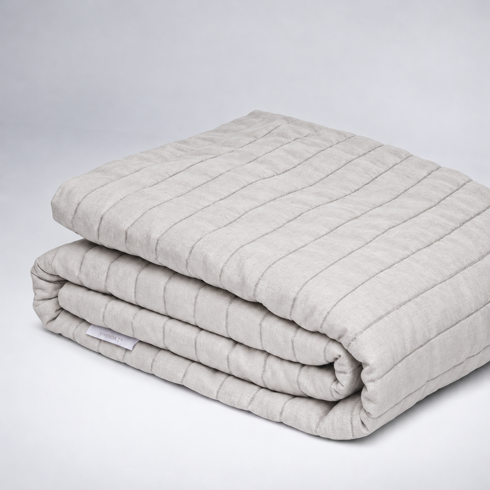 Coverlet Monte de lino en tono Bruma, acolchado y doblado.