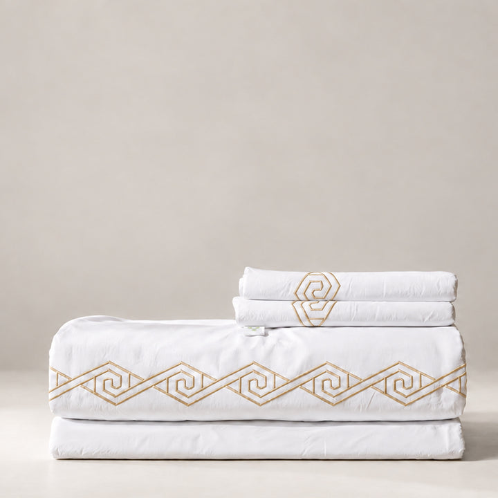 Juego de Sábanas Senda blanco con bordado Khaki en espiral y fundas de almohada, presentado doblado.