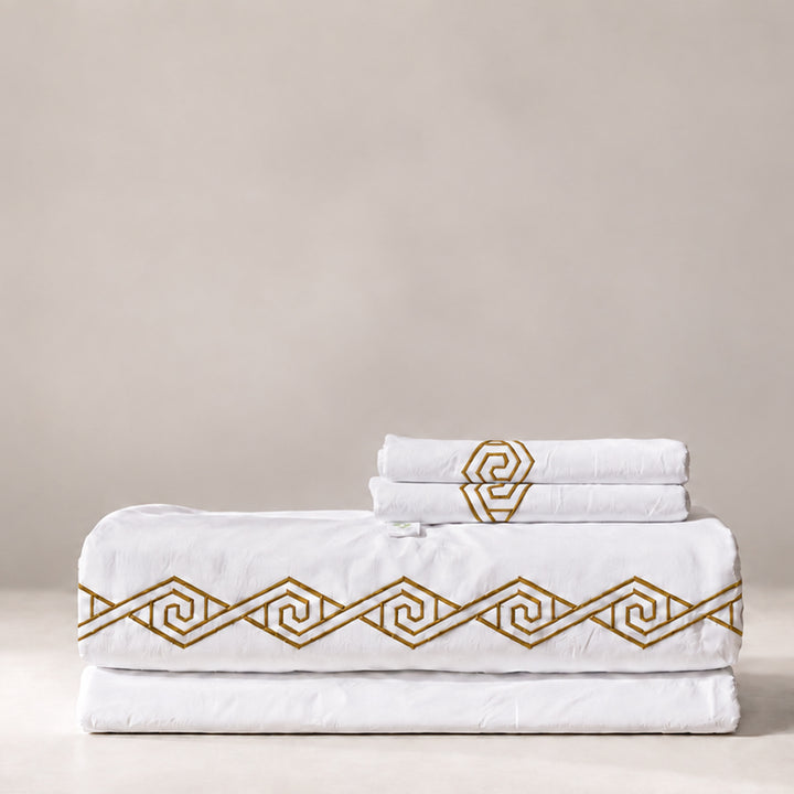 Juego de Sábanas Senda blanco con bordado Sunset en espiral y fundas de almohada, presentado doblado.