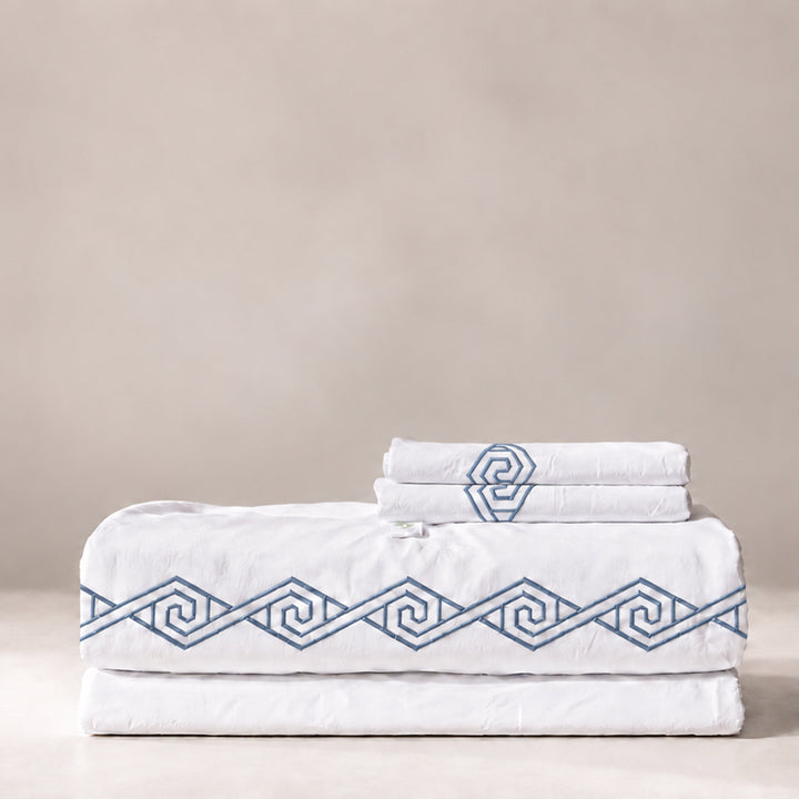 Juego de Sábanas Senda blanco con bordado Zen en espiral y fundas de almohada, presentado doblado.